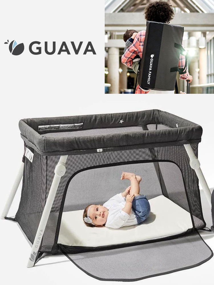 a baby playing in the guava family lotus travel crib