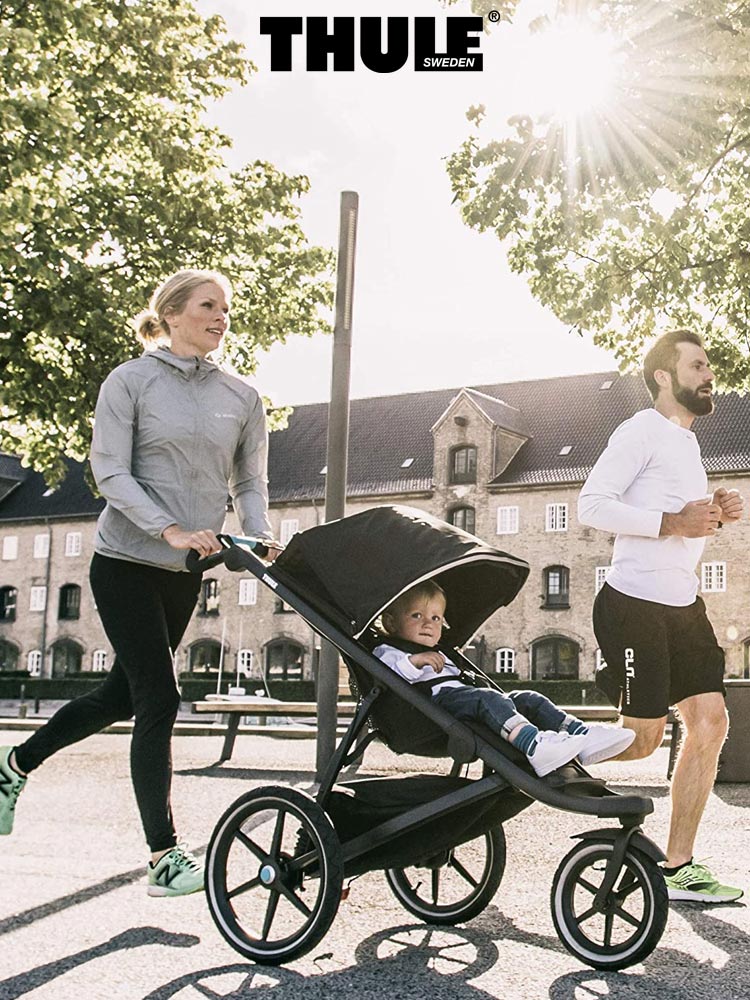 parents jogging with the thule urban glide 2 in a classic european urban setting